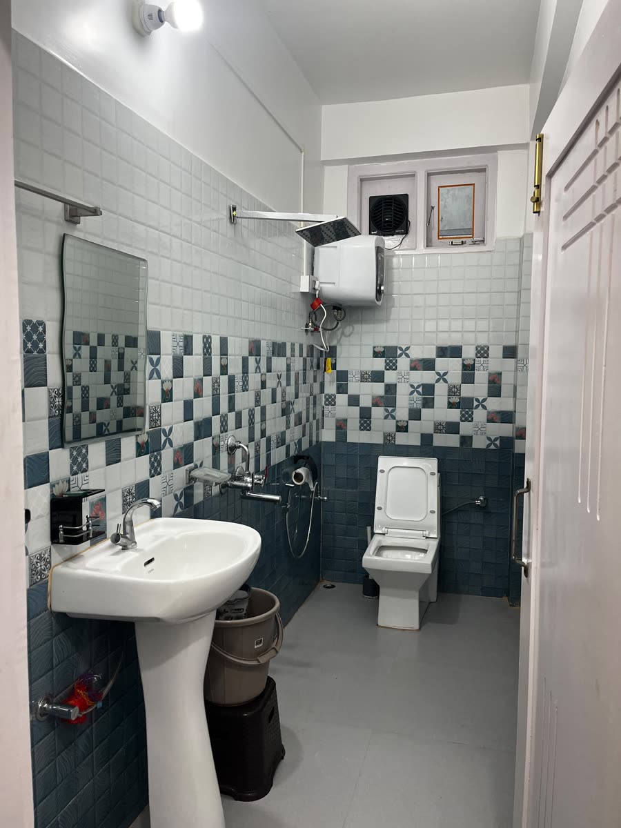 Tiled bathroom with geyser hot water and basin at Gonpapa Homestay