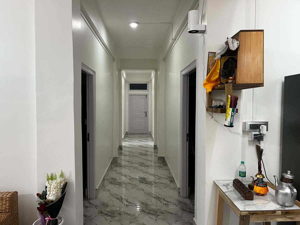 Bright marble-floored corridor leading to guest rooms at Gonpapa Homestay