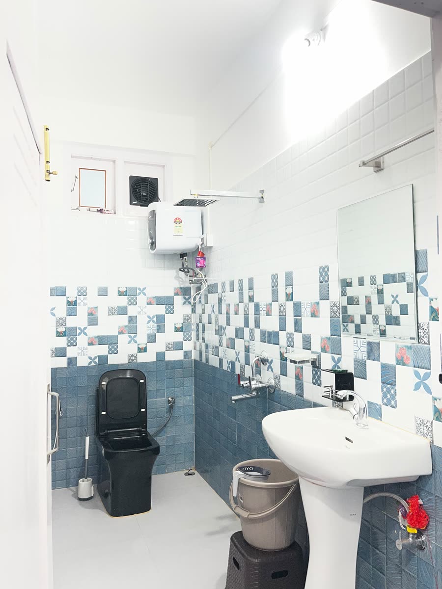 En-suite bathroom with shower, geyser and washbasin at Gonpapa Homestay