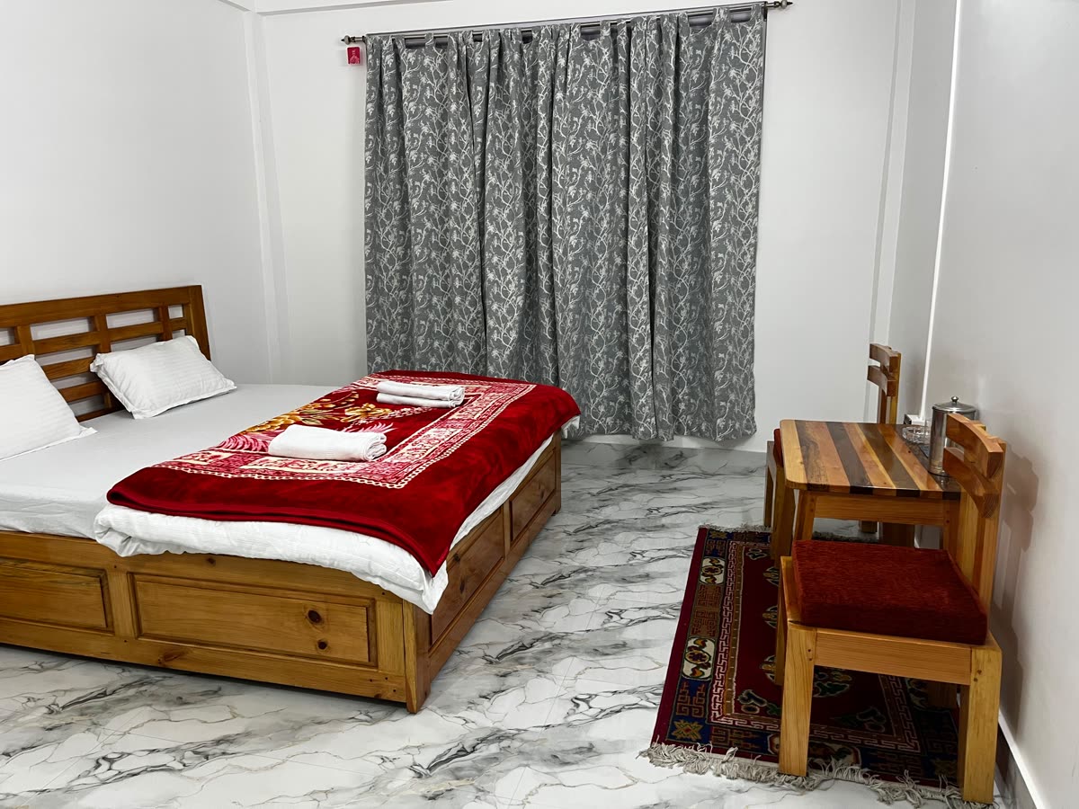 Guest room with warm blankets and fresh towels at Gonpapa Homestay, Dirang