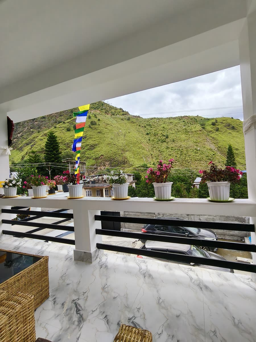 Dirang valley and green hills seen from the homestay balcony with prayer flags